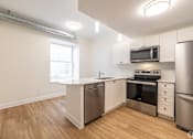 Thumbnail 8 of 20 - a renovated kitchen with white cabinets and stainless steel appliances
