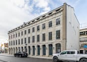 Thumbnail 19 of 20 - a large white building with many windows on a city street
