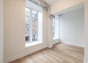 Thumbnail 5 of 20 - a living room with two windows and a wooden floor