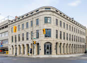 Thumbnail 17 of 20 - a large stone building on the corner of a city street