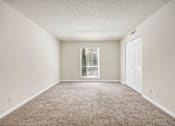 Thumbnail 11 of 25 - A room with a carpeted floor and a window with blinds.