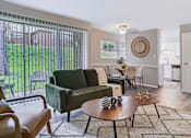 Thumbnail 1 of 38 - A living room with a green couch and a wooden coffee table.
