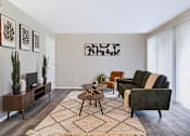 Thumbnail 4 of 38 - A living room with a couch, chair, and potted plants.