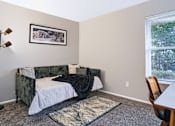 Thumbnail 17 of 38 - A bedroom with a bed, chair, and a picture on the wall.