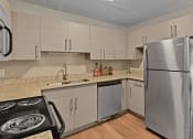 Thumbnail 6 of 39 - An updated kitchen with white cabinets and granite countertops at Heritage Hill Estates Apartments, Cincinnati, Ohio 45227
