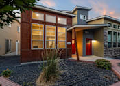 Thumbnail 13 of 61 - A modern house with a red door and a stone wall. at Verraso Village Apartments, Meridian 83646
