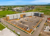 Thumbnail 79 of 98 - A large parking lot is surrounded by apartment buildings at The Beaumont Apartments, Bozeman, MT