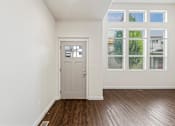Thumbnail 24 of 61 - A room with a grey door and a window with a view of trees. at Verraso Village Apartments, Idaho