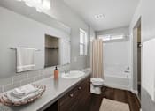 Thumbnail 4 of 28 - the bungalow bathroom has a large mirror and a shower and sink
