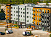 Thumbnail 76 of 98 - A parking lot with a few cars and a building in the background at The Beaumont Apartments, Montana, 59715