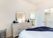 Thumbnail 12 of 35 - a bedroom with a bed and a dresser with a mirror at Corso Apartments, Missoula, MT