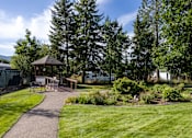 Thumbnail 11 of 31 - a park with a picnic area and a gazebo