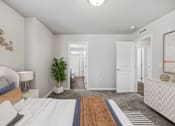 Thumbnail 3 of 28 - a bedroom with a large bed and a door to a hallway
