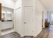 Thumbnail 8 of 35 - a bedroom with white doors and a bathroom with a sink and a mirror at Corso Apartments, Missoula, MT