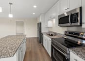 Thumbnail 1 of 98 - A kitchen with granite countertops and stainless steel appliances at The Beaumont Apartments, Montana, 59715