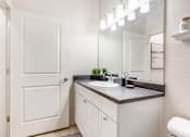 Thumbnail 3 of 35 - a bathroom with a sink and a mirror and a door at Corso Apartments, Missoula, MT