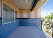 Thumbnail 6 of 23 - A balcony with a metal railing and a window with a view of trees.