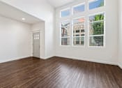 Thumbnail 28 of 61 - A room with a wooden floor and a door leading to another room. at Verraso Village Apartments, Meridian 83646