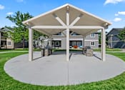 Thumbnail 26 of 40 - A pavilion with a white roof and pillars is surrounded by a grassy area.