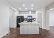 Thumbnail 31 of 61 - A kitchen with a black fridge and a granite counter top. at Verraso Village Apartments, Meridian