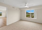Thumbnail 10 of 98 - A room with a window showing a view of a mountain and a fan on the ceiling at The Beaumont Apartments, Montana, 59715