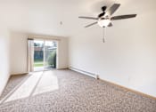 Thumbnail 3 of 31 - an empty living room with a ceiling fan and a sliding glass door