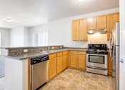 Thumbnail 5 of 23 - A kitchen with wooden cabinets and stainless steel appliances.