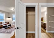 Thumbnail 12 of 27 - A white door is open to a room with a kitchen and a living room.