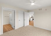 Thumbnail 12 of 98 - A room with a ceiling fan and a mirrored closet door at The Beaumont Apartments, MT 59715