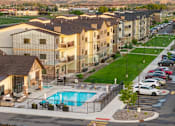 Thumbnail 42 of 46 - Apartment complex with a pool in the foreground.