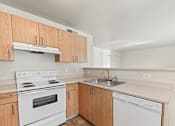 Thumbnail 71 of 73 - A kitchen with a white stove top oven and a white dishwasher.
