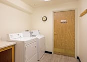 Thumbnail 31 of 31 - a laundry room with washers and dryers and a door to a room with