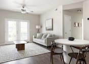 Thumbnail 14 of 26 - a living room with a couch a table and a ceiling fan at The Alloy at Geneva, Utah