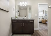 Thumbnail 7 of 26 - a bathroom with dark cabinets and granite countertops at The Alloy at Geneva, Vineyard, Utah