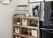 Thumbnail 4 of 26 - a shelf with baskets and plants next to a coffee machine in a living room at The Alloy at Geneva, Vineyard, UT, 84058