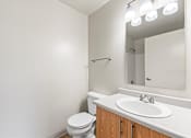 Thumbnail 73 of 73 - A white bathroom with a toilet, sink, and mirror.