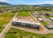 Thumbnail 83 of 98 - A large building with a parking lot in front of it at The Beaumont Apartments, Bozeman, 59715