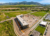 Thumbnail 81 of 98 - A large building with a parking lot in front of it at The Beaumont Apartments, Bozeman