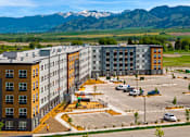 Thumbnail 55 of 98 - A large parking lot in front of a multi-story building at The Beaumont Apartments, Bozeman, Montana 59715