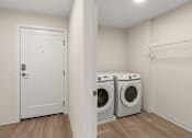 Thumbnail 14 of 98 - A laundry room with a white sliding door door and two washing machines at The Beaumont Apartments, Bozeman, Montana 59715