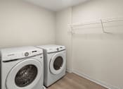 Thumbnail 13 of 98 - Two white front loading washing machines in a laundry room at The Beaumont Apartments, MT 59715