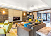 Thumbnail 23 of 35 - a living room with couches and chairs and a fireplace at Corso Apartments, Missoula, MT