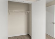 Thumbnail 11 of 98 - A white closet with a hanger bar and a white door at The Beaumont Apartments, MT 59715