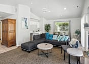 Thumbnail 13 of 26 - A living room with a grey couch and a wooden cabinet.at Country Oaks Apartments, Clearfield