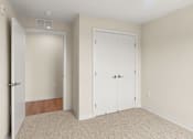 Thumbnail 9 of 98 - A room with two white doors and a carpeted floor at The Beaumont Apartments, Bozeman, 59715