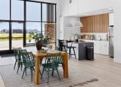 Thumbnail 9 of 45 - an open kitchen and dining area with a wooden table and green chairs at The Expo, Montana, 59106