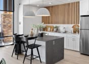 Thumbnail 8 of 45 - a kitchen with white cabinets and a gray island at The Expo, Billings, MT