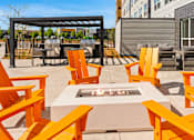 Thumbnail 73 of 98 - A patio with orange chairs and a fire pit at The Beaumont Apartments, Bozeman, Montana 59715