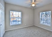 Thumbnail 37 of 60 - a bedroom with two windows and a ceiling fan at The Vineyards of Colorado Springs, Colorado Springs, CO
