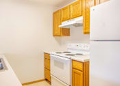 Thumbnail 8 of 31 - a kitchen with white appliances and wooden cabinets and a refrigerator